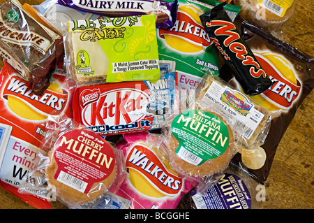 a selection of snacks like crisps and chocolate on sale at a small delicatessen Stock Photo