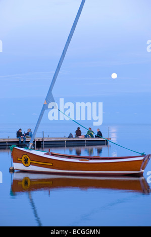 People relax on wooden pier overlooking Puck Bay early evening Hel Peninsula Baltic Sea Poland Stock Photo