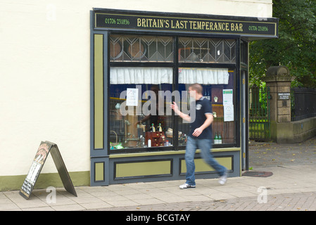 Man walking past Fitzpatrick's Herbal Health temperance bar, Rawtenstall, Lancashire, England UK Stock Photo