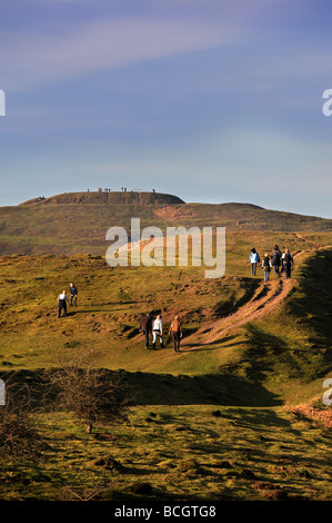 WALKERS ON BRITISH CAMP AN IRON AGE HILL FORT ON THE MALVERN HILLS ON AN EARLY SPRING EVENING UK Stock Photo