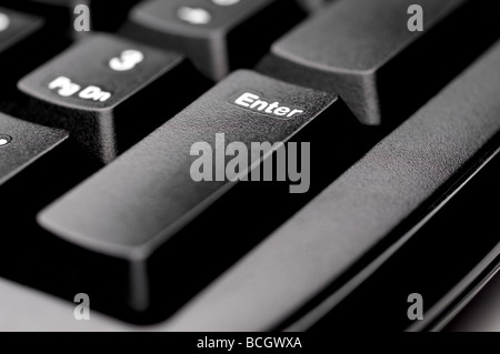 Horizontal shallow focus macro of an Enter key on a black computer keyboard Stock Photo
