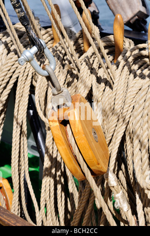 Single wood block surrounded by furled lines and rigging on large sailing vessel Stock Photo