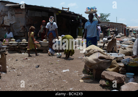 young girls sorting through dirt on market floor for rice grains in Ghana Stock Photo