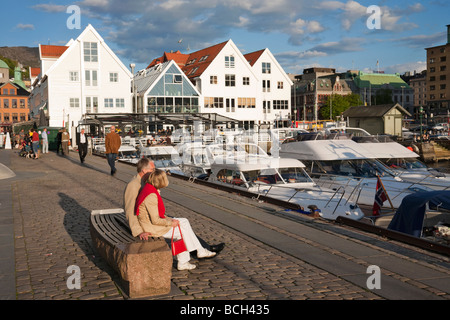 Senior couple sitting on a stone bench at the harbour in Bergen Norway Stock Photo