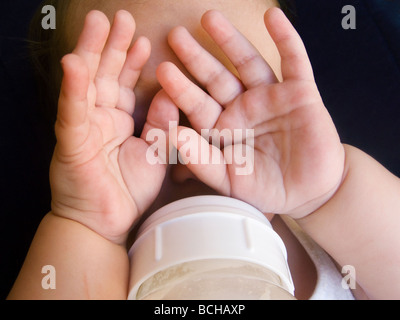 6 month baby boy being bottle fed and nodding off to sleep Stock Photo