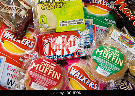 a selection of snacks like crisps and chocolate on sale at a small delicatessen Stock Photo