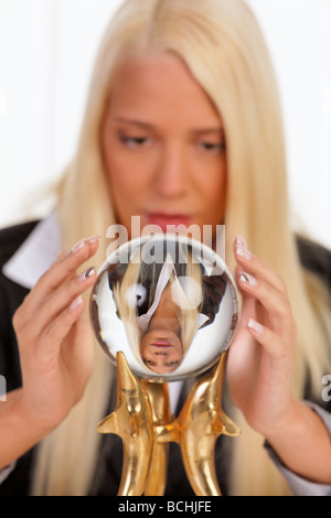 Young woman reads the future from a crystal ball in her hands Stock Photo