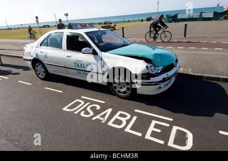 A damaged cab, after a road accident, parked in a disabled bay Stock Photo