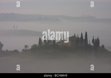 Farm house near San Quirico d'Orcia with morning fog Stock Photo