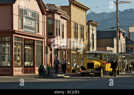 Man poses in front of a yellow *Skagway Street Car* during Summer in Southeast Alaska Stock Photo