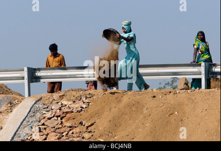 Woman in sari moves roadworks dirt Gujarat India Stock Photo