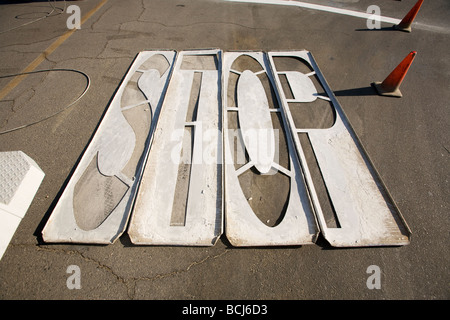 Wood stencils for painting STOP on pavement laying on asphalt street with orange traffic cones Indio California USA Stock Photo