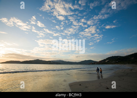 Zihuatanejo Mexico Male and female couple walking on beach of Playa La Madera in Zihuatanejo Mexico during dramatic sunset Stock Photo