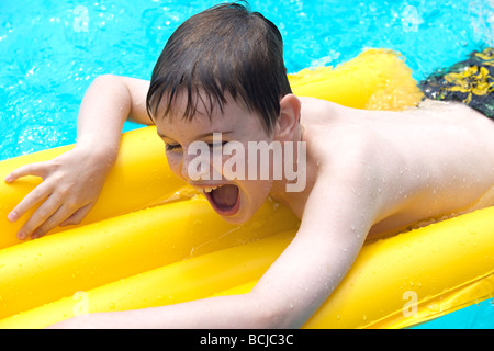 BOY ON LILO IN POOL Stock Photo - Alamy