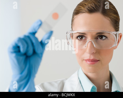 Female scientist holding litmus paper Stock Photo