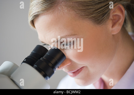 Female scientist using a microscope Stock Photo