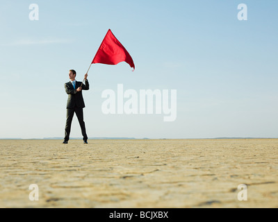 Businessman holding a red flag Stock Photo