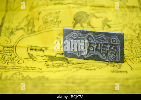 The most popular Tibetan mantra 'Om Mani Padme Hum' carved on a little stone plate. Stock Photo