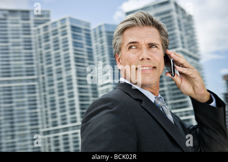 Senior executive uses cellular phone outdoors in a city environment Stock Photo