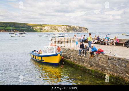 Families crabbing off the harbour wall and a boat for pleasure trips around the bay.  Seaside town of Swanage, Dorset. UK Stock Photo