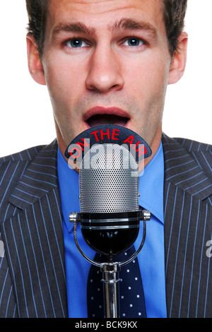 Close up portrait of a businessman talking into a microphone with an On the Air sign on it Stock Photo
