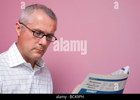 Businessman reading the latest share prices in a financial newspaper Stock Photo