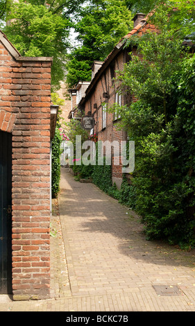 Narrow ally between red brick buildings in a typical Dutch surrounding Stock Photo