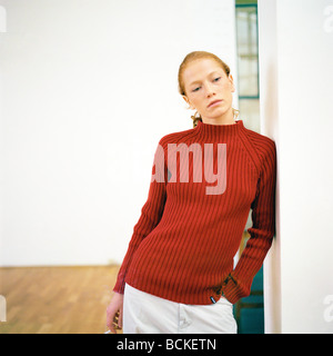 Young woman leaning against wall Stock Photo