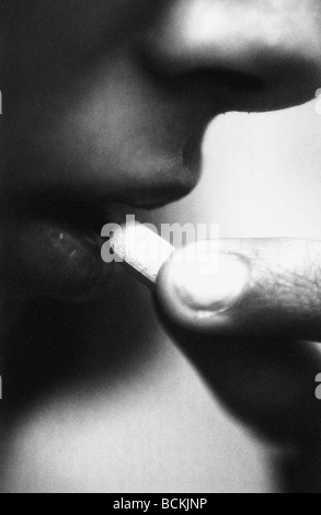 Person taking pill, close-up, b&w Stock Photo