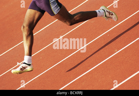 Runner running on clay track, lower section Stock Photo