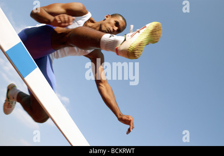 Athlete jumping hurdle, low angle view Stock Photo