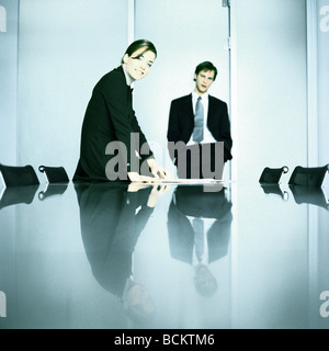 Businessman and businesswoman standing at table Stock Photo