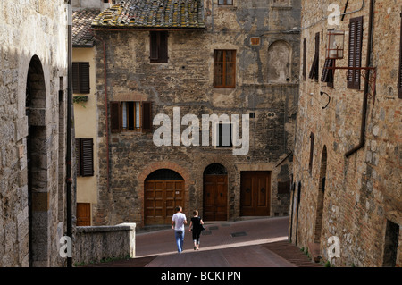 A romantic couple walking through the streets of San Gimignano in Tuscany, Italy, Europe Stock Photo