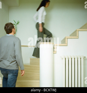 Man and woman walking up steps, interior Stock Photo