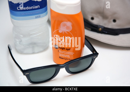 Hot weather precautions: water, sunblock, glasses, hat Stock Photo