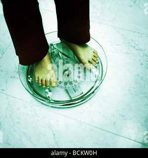 Woman standing on scale, lower section Stock Photo