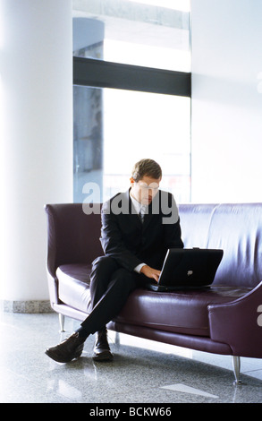 Businessman using laptop computer on sofa Stock Photo