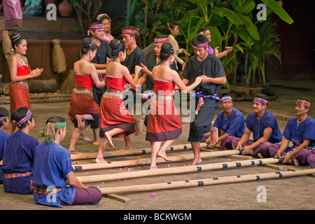 Thailand. Thai men and women perform the energetic Bamboo Dance of northeastern Thailand at the Rose Garden. Stock Photo