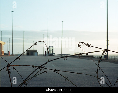 Barbed wire in front of parking lot Stock Photo