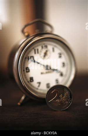 Alarm clock and coin Stock Photo