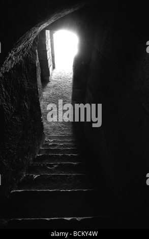 Dark staircase with light coming from doorway, black and white Stock Photo