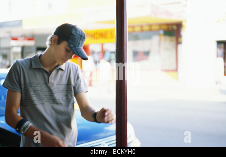 Young man standing near car, waist up Stock Photo