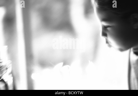 Child blowing out birthday candles, defocused