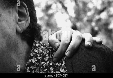 Young woman's hand on elderly woman's shoulder Stock Photo