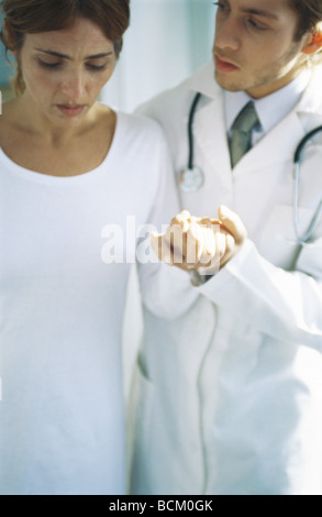 Doctor holding female patient's hand Stock Photo