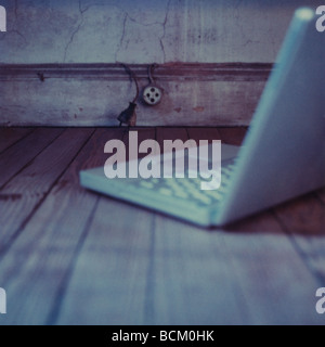 Laptop on hardwood floor Stock Photo