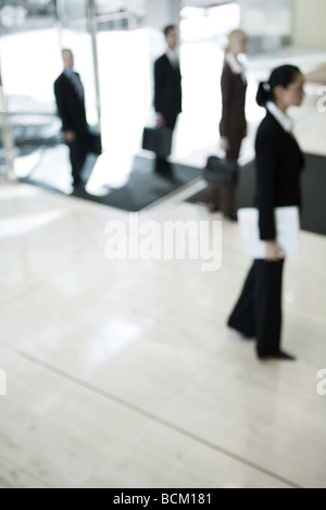 Business people entering lobby, side view, defocused Stock Photo