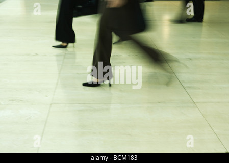 Businesswomen walking, blurred motion, low section Stock Photo