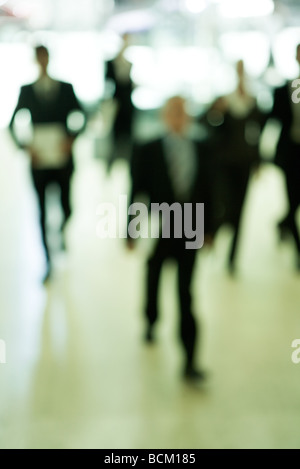 Business people walking through lobby, front view, defocused Stock Photo