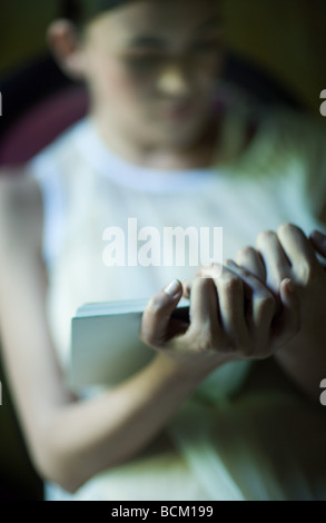 Woman reading, focus on hands in foreground, close-up Stock Photo